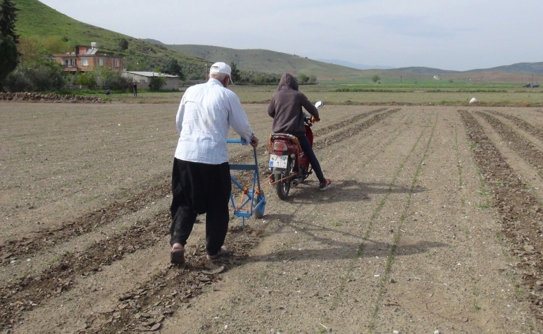 Motosikleti ile tarlasını sürüyor