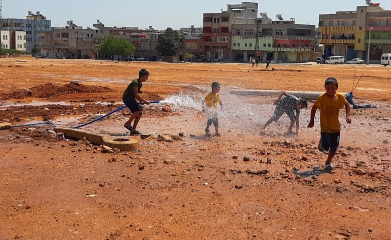 Çocuklar çamurda halay çekip, hortumla serinledi